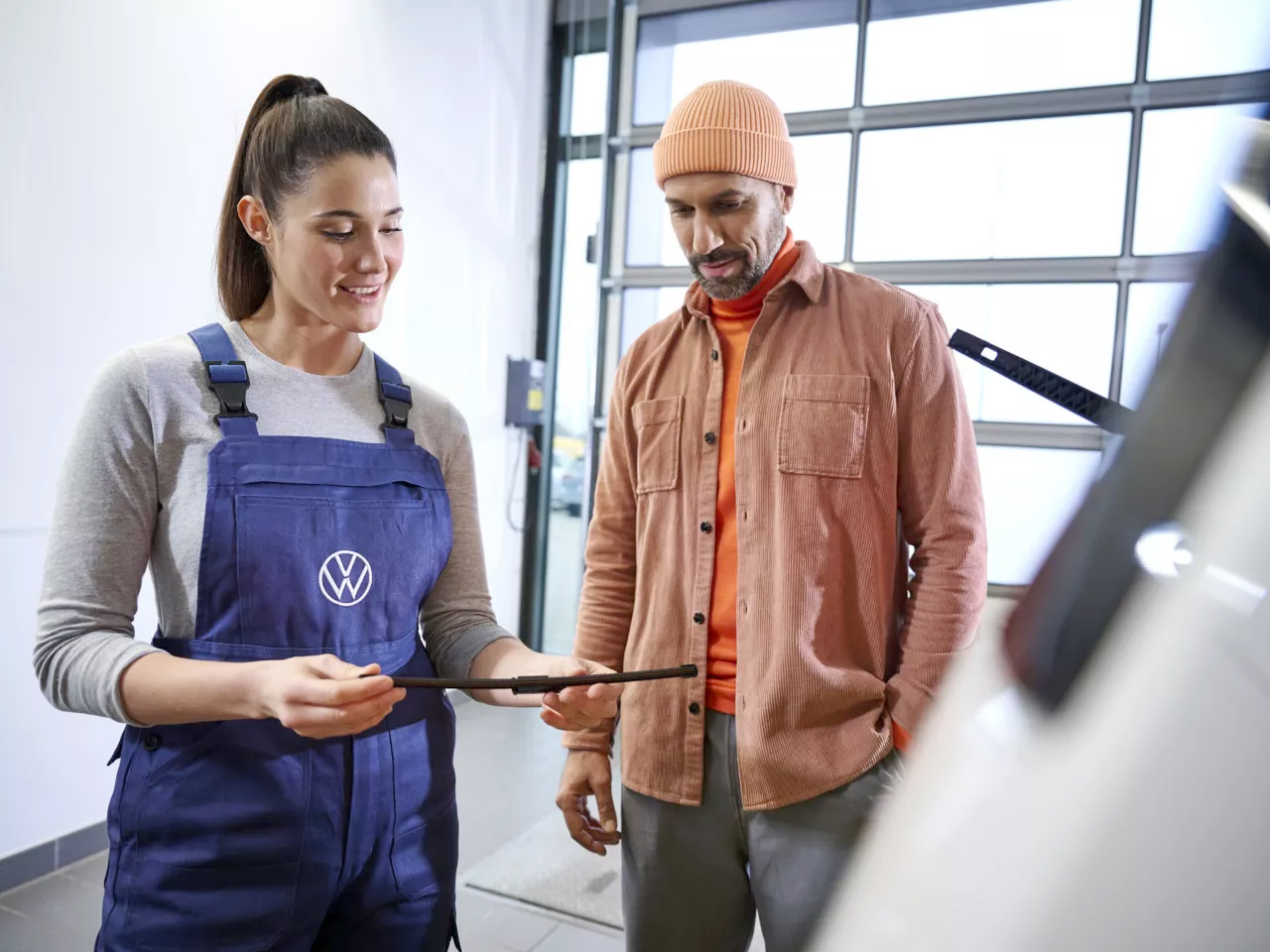 Un'addetta officina illustra al cliente con l'ipad il lavoro da eseguire